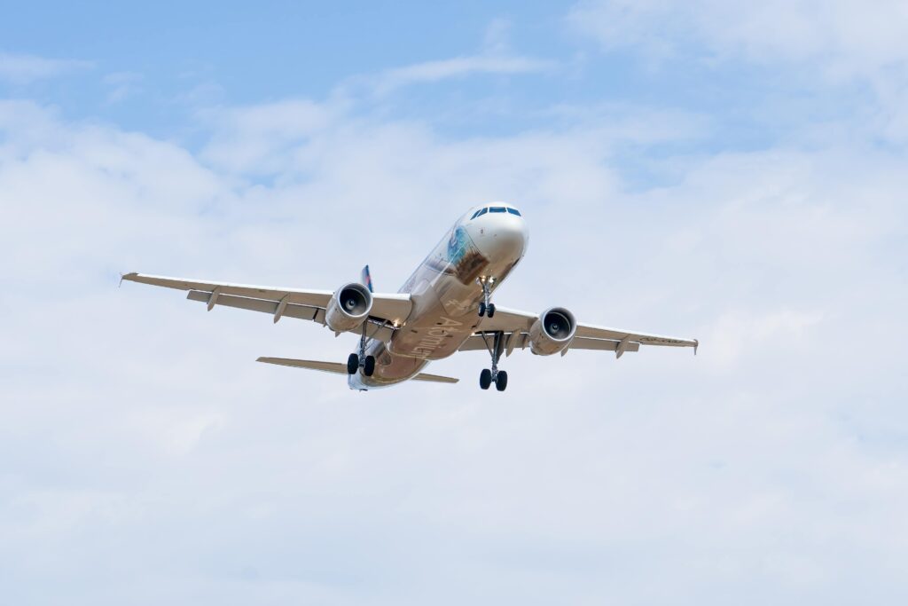 An airliner captured in flight with a clear blue sky, showcasing commercial aviation above Manises, Spain.